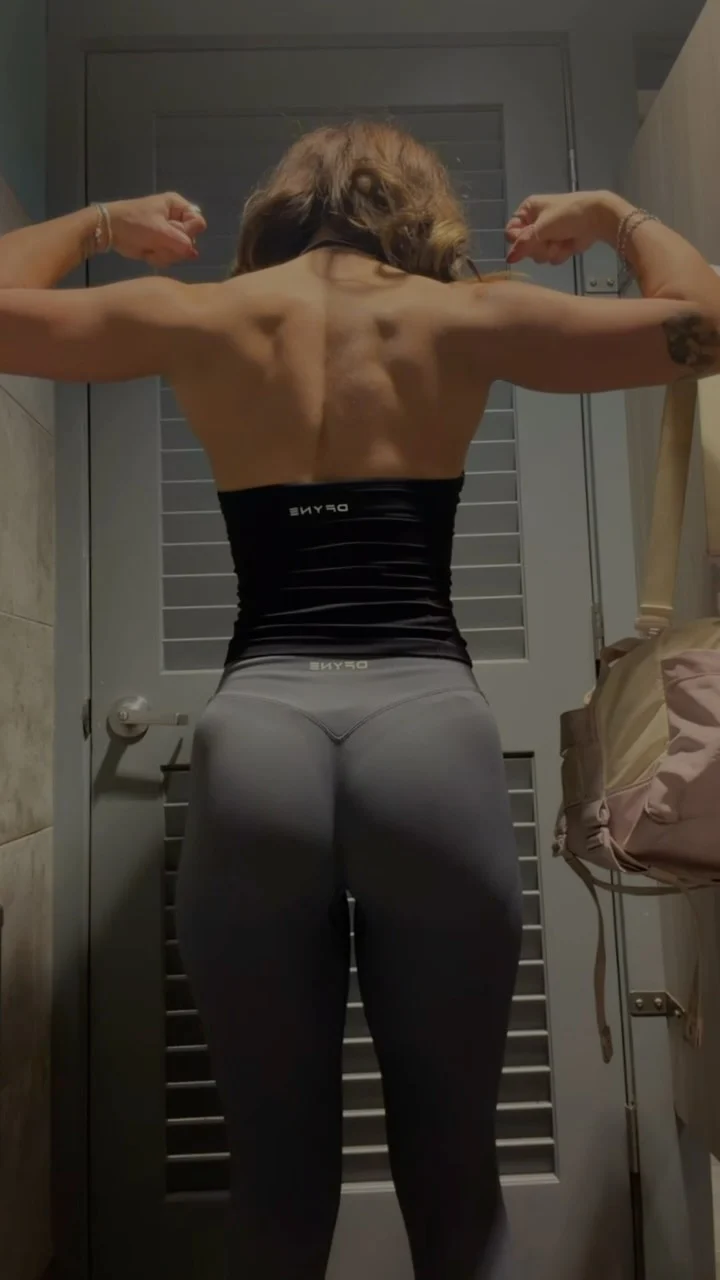 Natasha showing her back training progress in a gray workout outfit