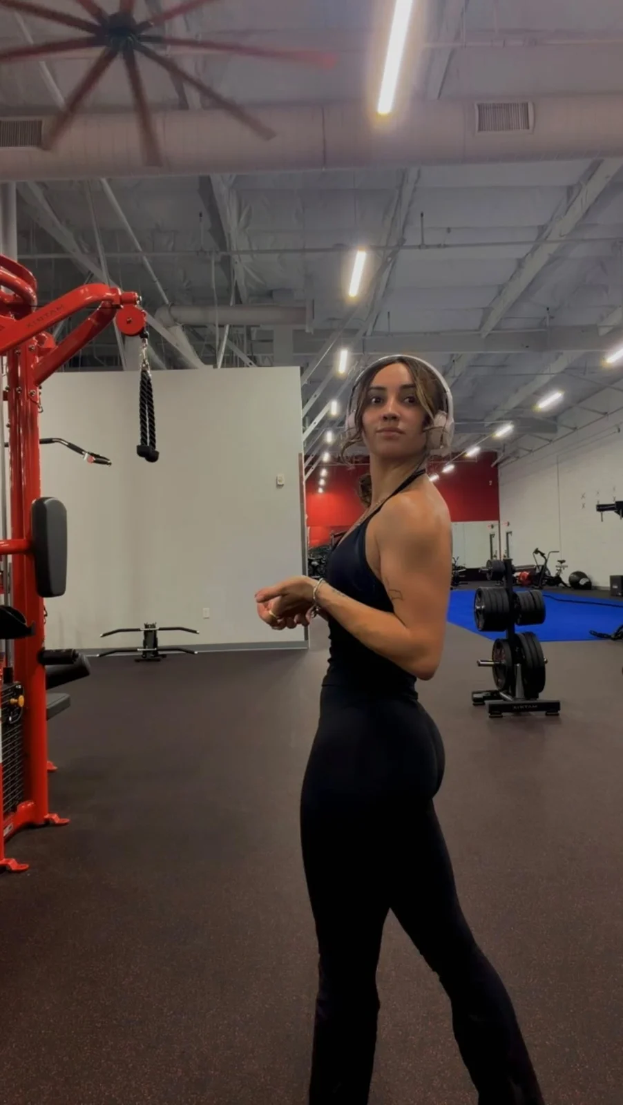 Natasha in black gymwear beside red training equipment